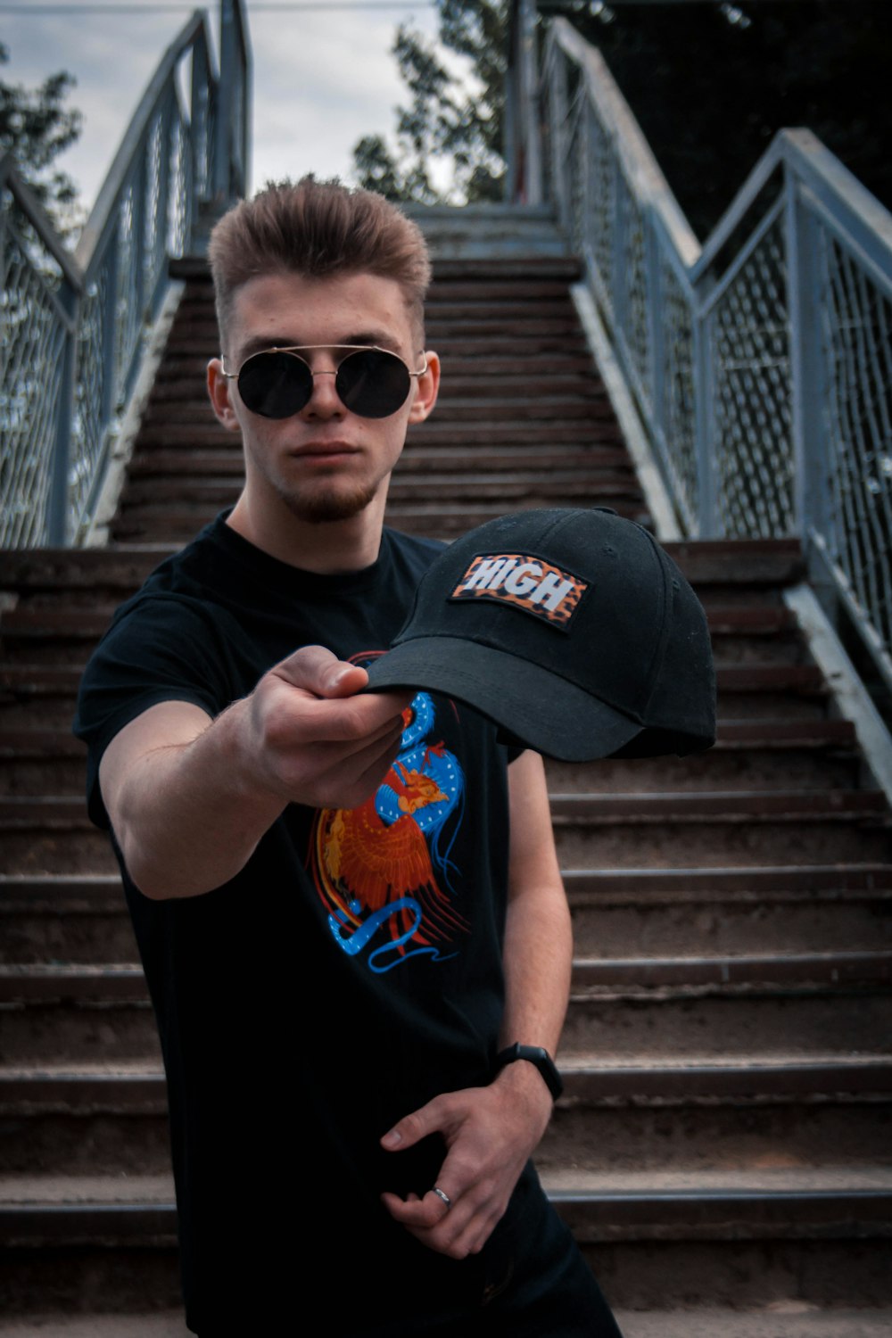 man in black and orange crew neck t-shirt wearing black sunglasses