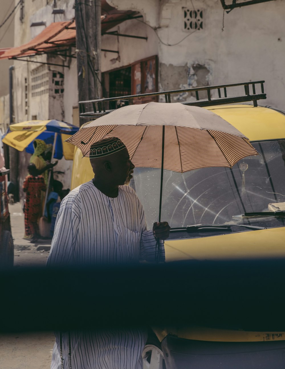 homme en chemise rayée blanche et noire tenant un parapluie