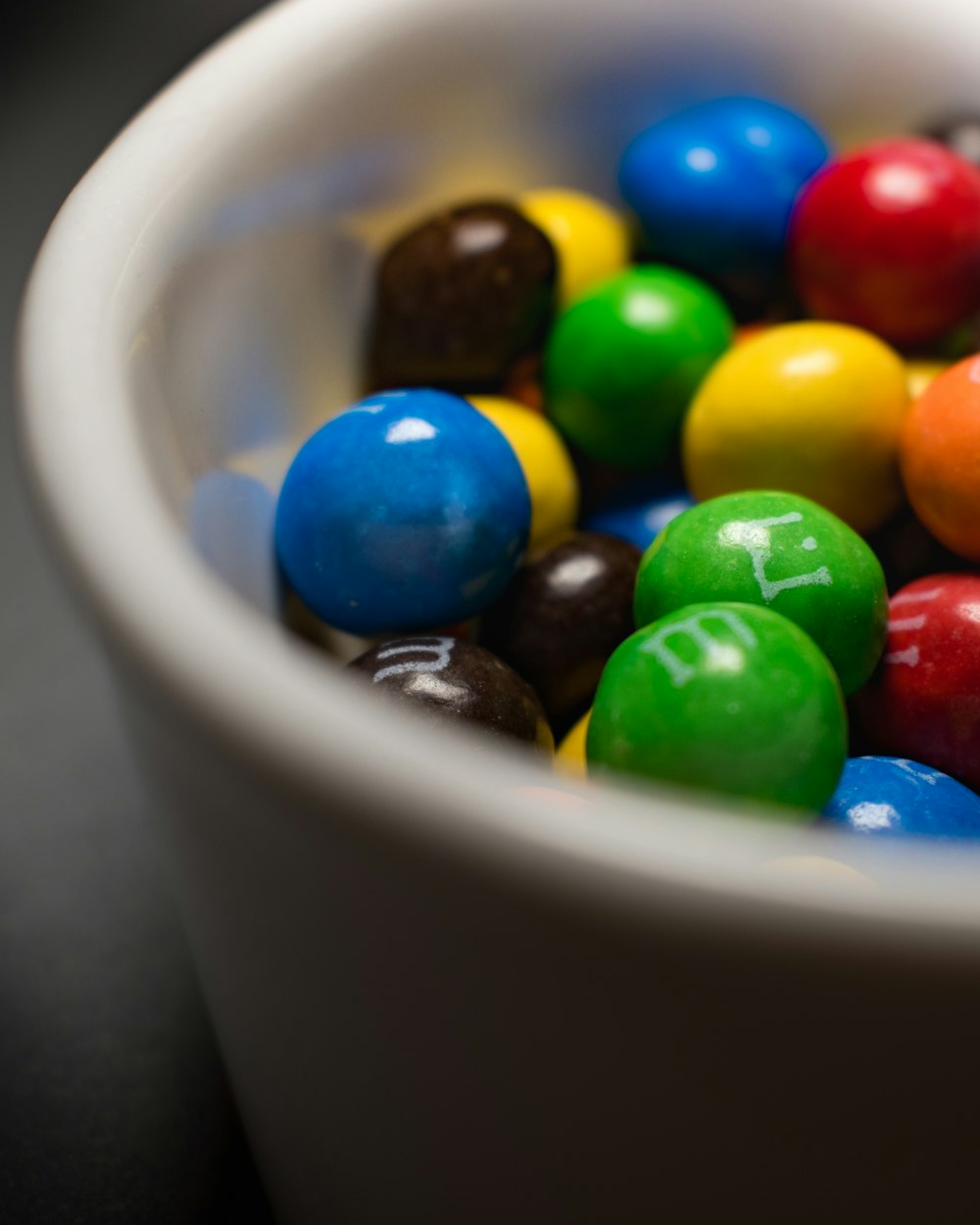un bol blanc rempli de bonbons colorés