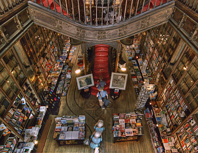 Overhead view of the ornate dark-wood spiral staircase inside Livraria Lello bookshop in Porto.
