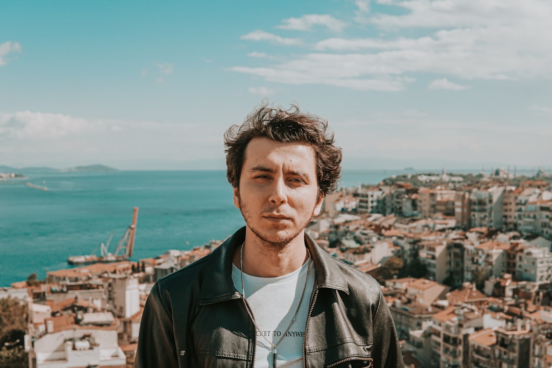 man in black leather jacket standing on top of building during daytime