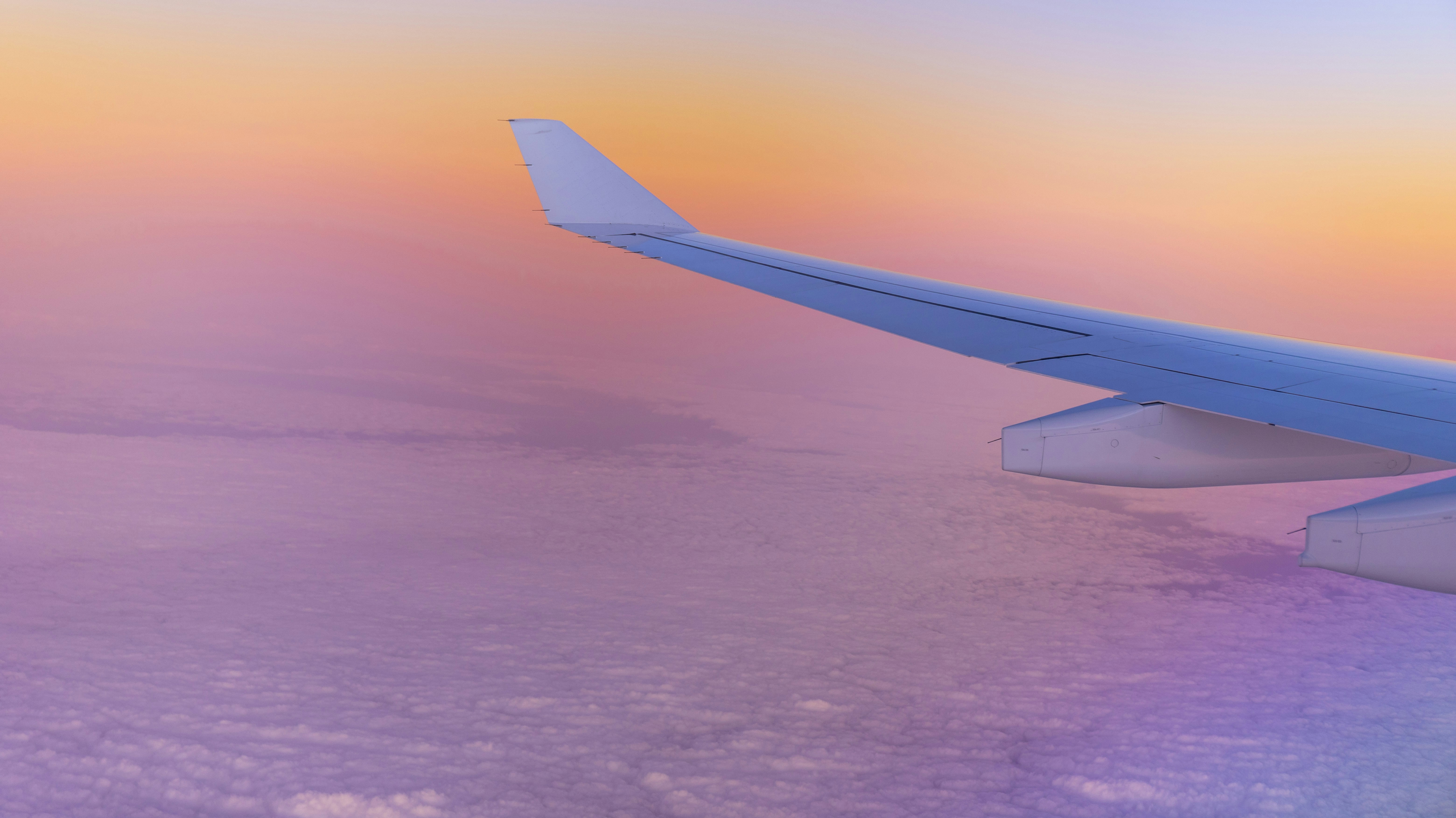 white airplane wing over the clouds during daytime, Photo of the sunset from above on a flight from Frankfurt to Dubai.