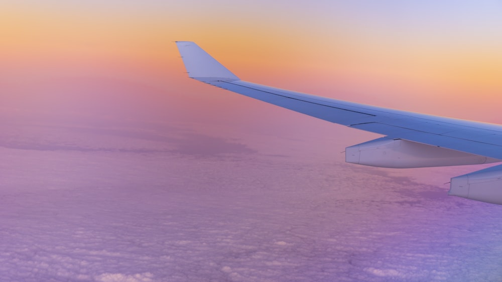 white airplane wing over the clouds during daytime