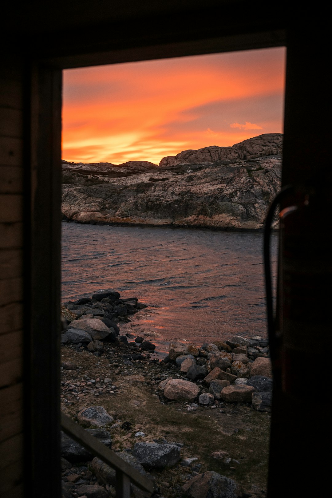 rocky shore near body of water during sunset