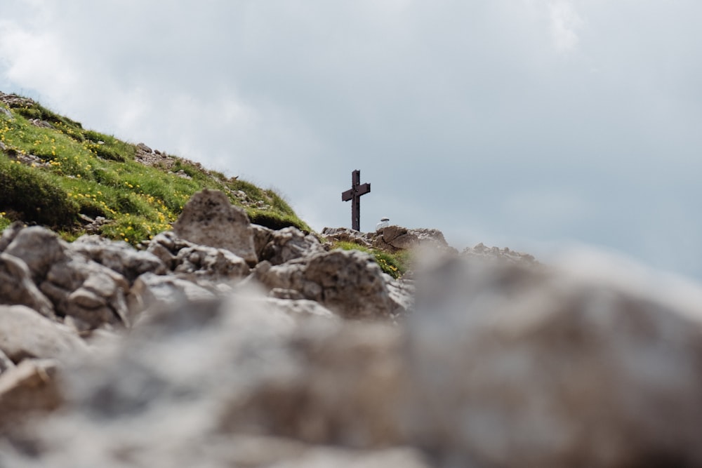 black cross on gray rocks under white sky during daytime