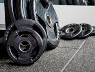 Stacked weight plates with a glossy finish, arranged neatly against a black backdrop.