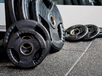 Stacked black and red weight plates neatly arranged, reflecting the gym’s clean and simple style.