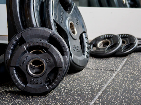 Stack of Fortiva weight plates with bold branding, ready for intense training.