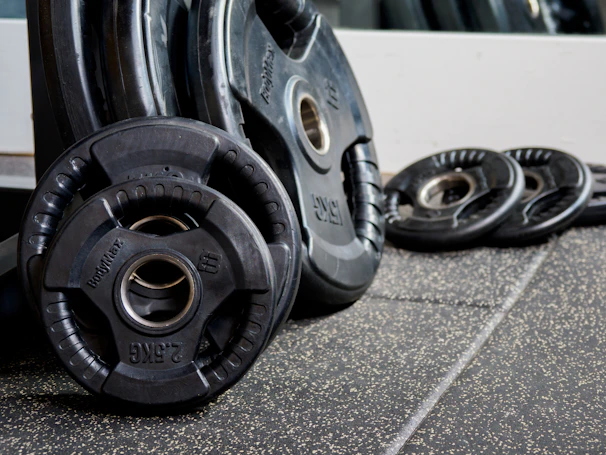 Stacked black and red weight plates neatly arranged, reflecting the gym’s clean and simple style.