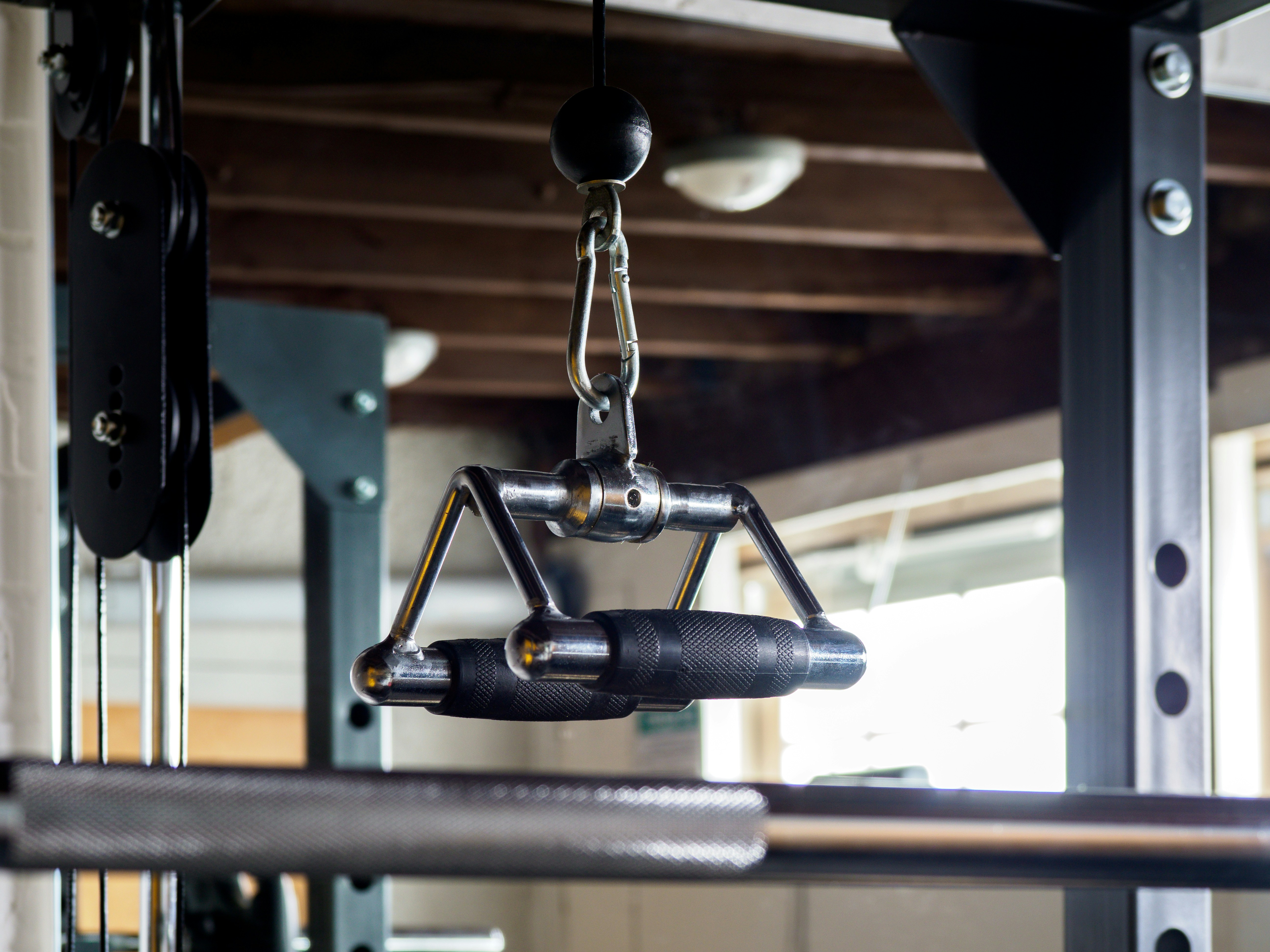 Cable machine handle hanging in a gym