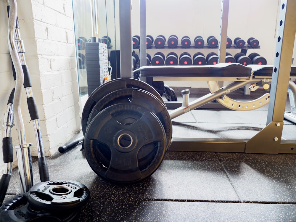 black and gray barbell on black and white floor tiles