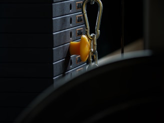 Close-up of a cable machine with weights in a well-lit gym area.