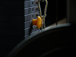 Close-up of hands performing maintenance on a set of weight machines.