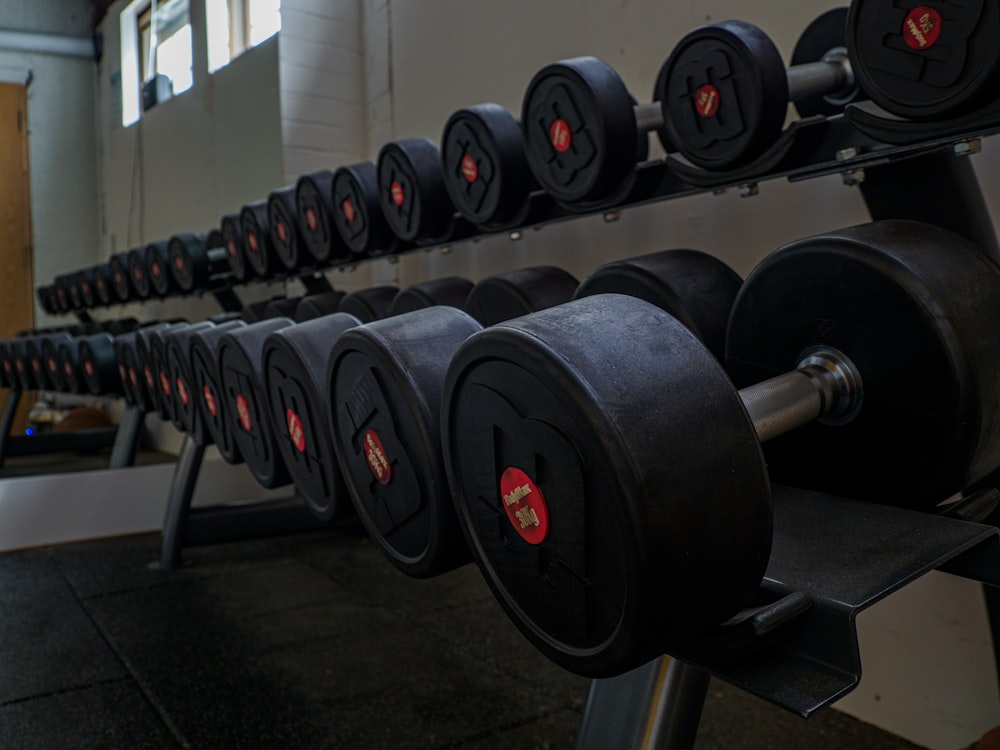 black and gray dumbbells on black rack