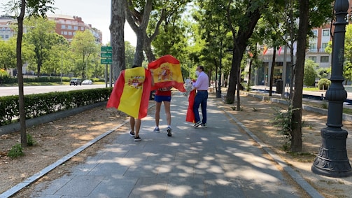 Two new immigrants and local mentors walking through a vibrant Spanish neighborhood