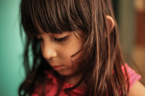 A delicate watercolor portrait capturing the gentle expression of a child lost in thought.