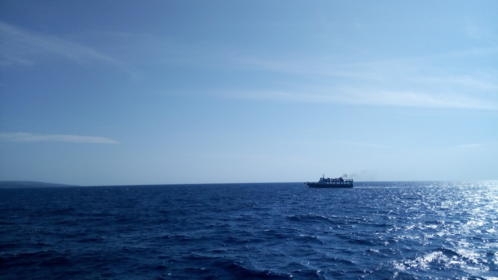 black ship on sea under blue sky during daytime