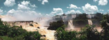 A vibrant panoramic view of Iguazu Falls with tourists enjoying the natural beauty