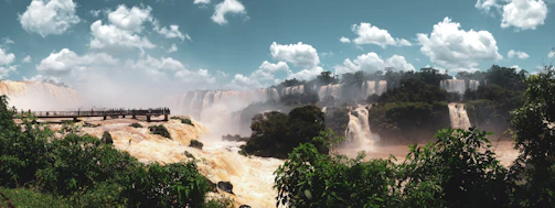 A vibrant panoramic view of Iguazu Falls with tourists enjoying the natural beauty