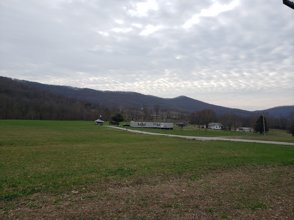 green grass field under cloudy sky during daytime