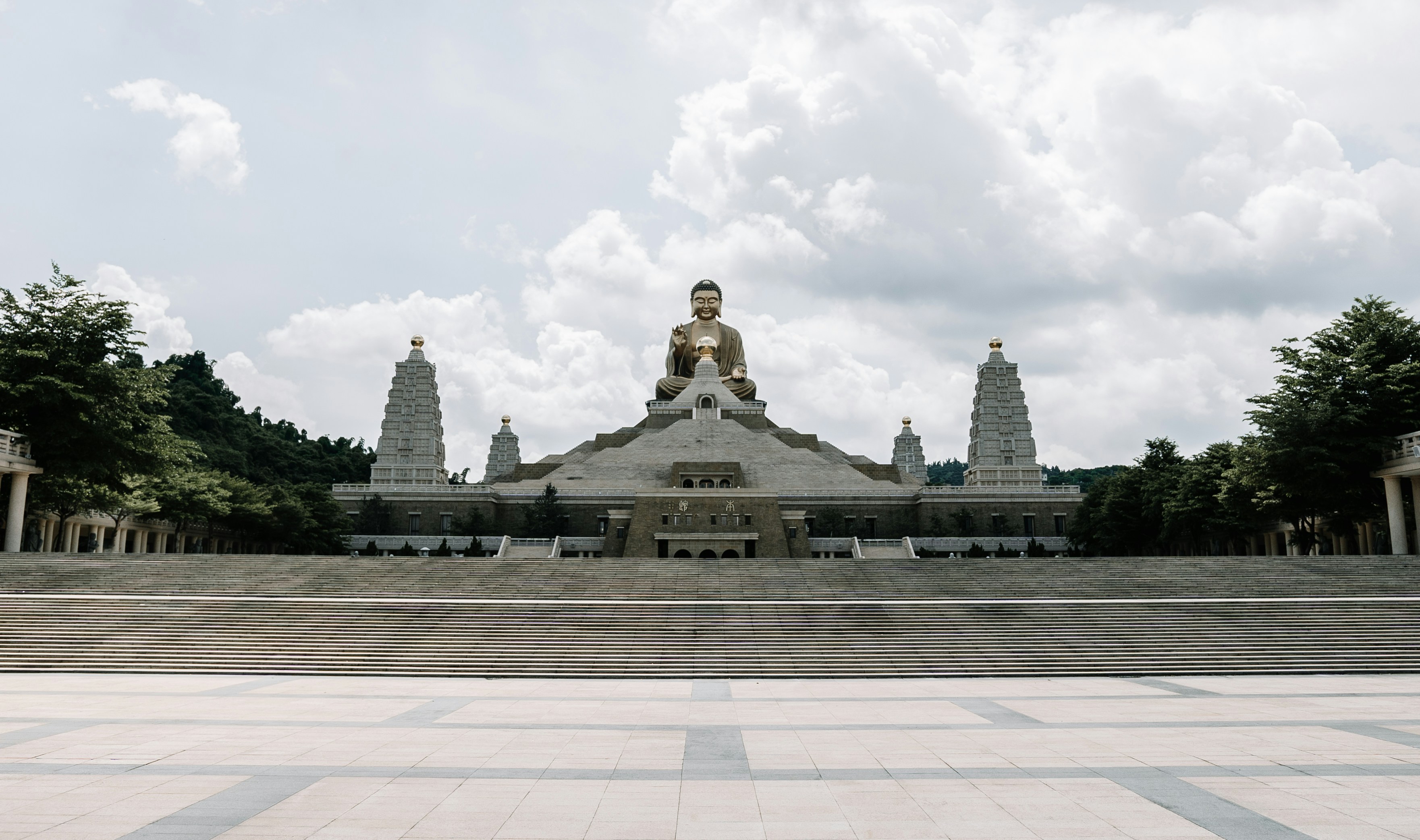 gold buddha statue under cloudy sky during daytime