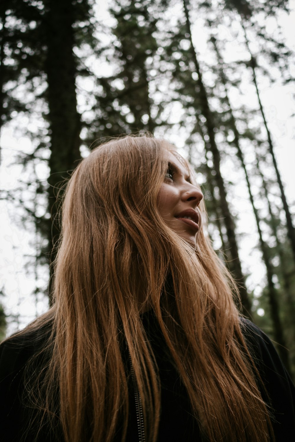 woman in black shirt standing near trees during daytime