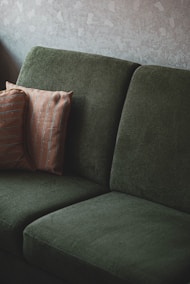 deep cleaned couch with green cushions and brown pillow