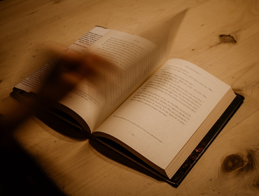 opened book on brown wooden table