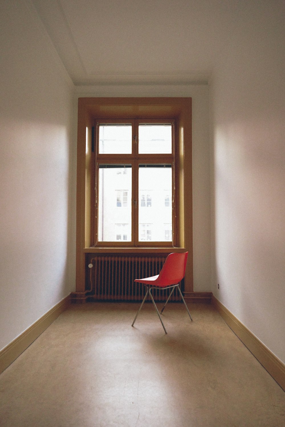 red and black chair beside window