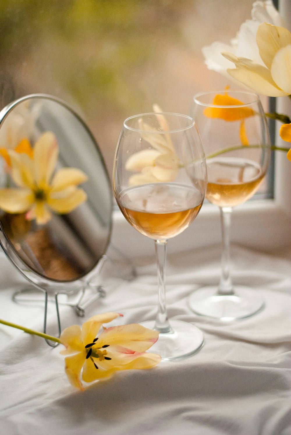 yellow flowers in clear wine glass