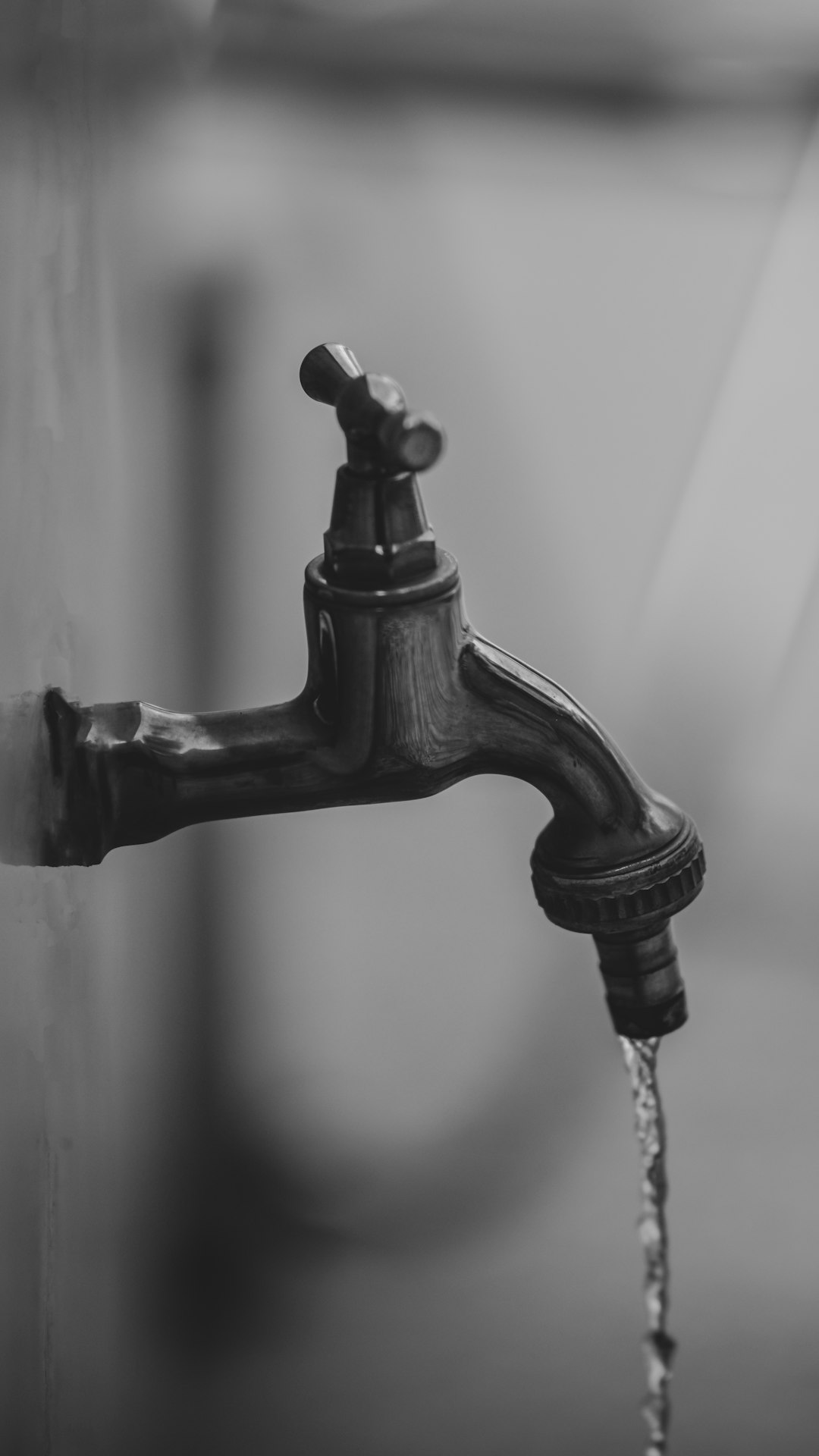  black faucet in grayscale photography tap