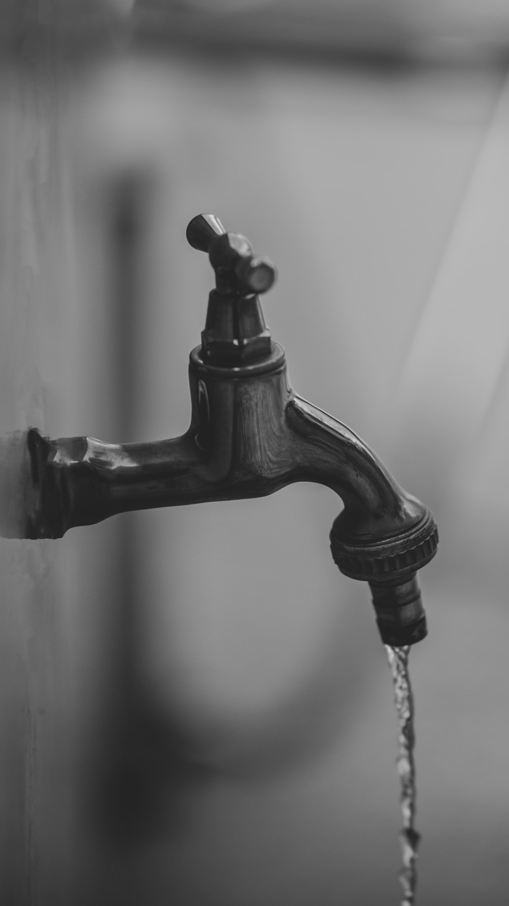 black faucet in grayscale photography