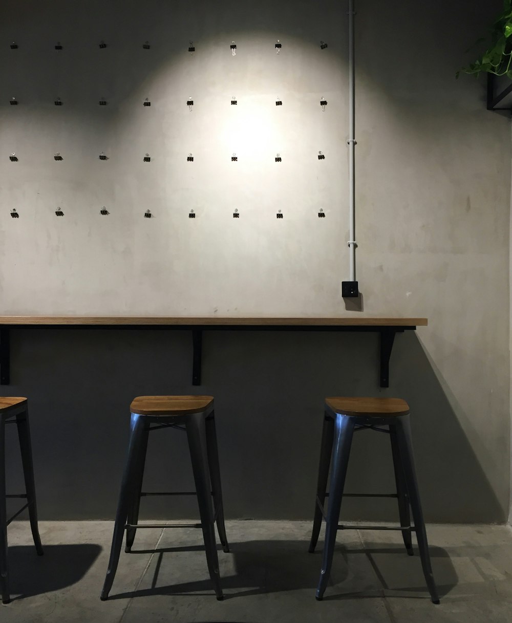 brown wooden table near white wall