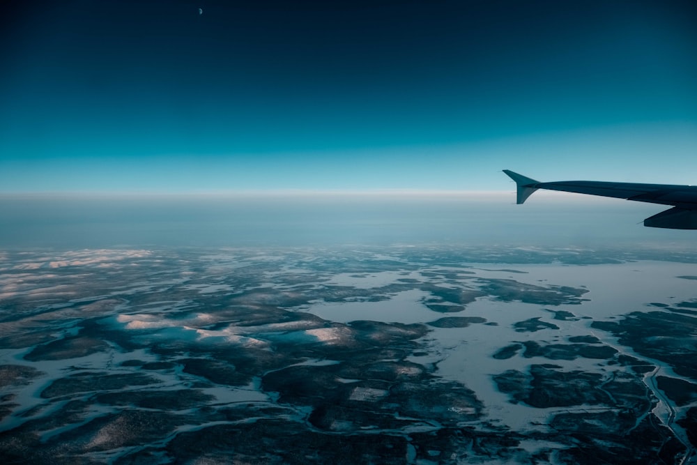 airplane flying over the clouds during daytime