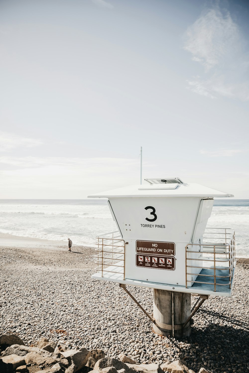 white lifeguard house on beach during daytime