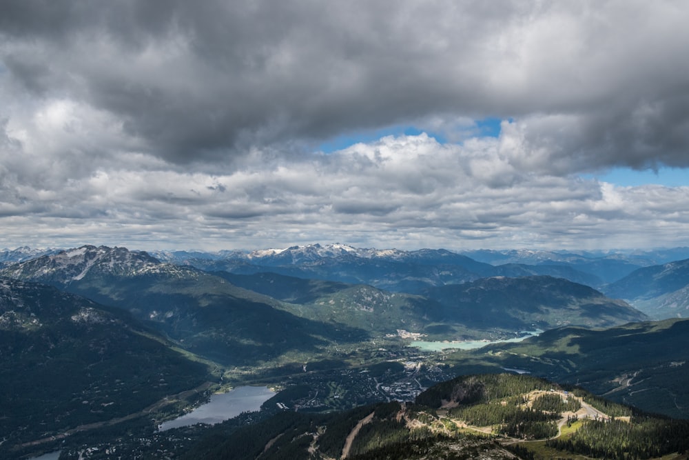 aerial view of green mountains under cloudy sky during daytime