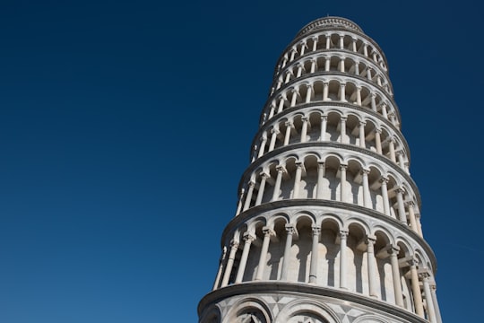 white concrete building under blue sky during daytime in Piazza dei Miracoli Italy