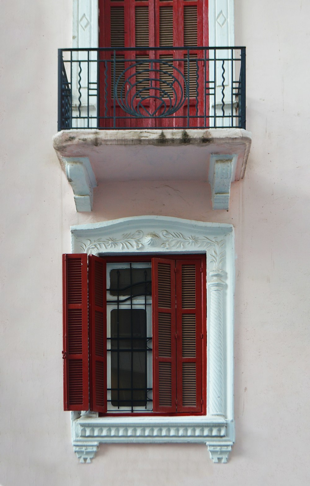 red wooden window on white concrete building