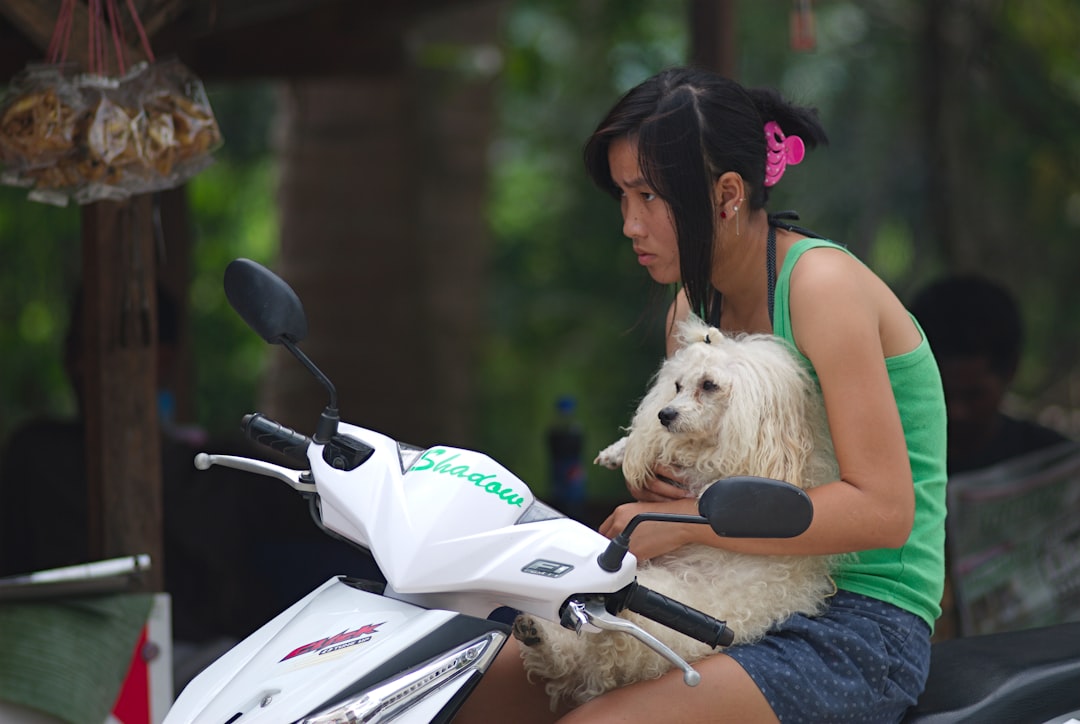 woman in pink tank top riding white and black motorcycle