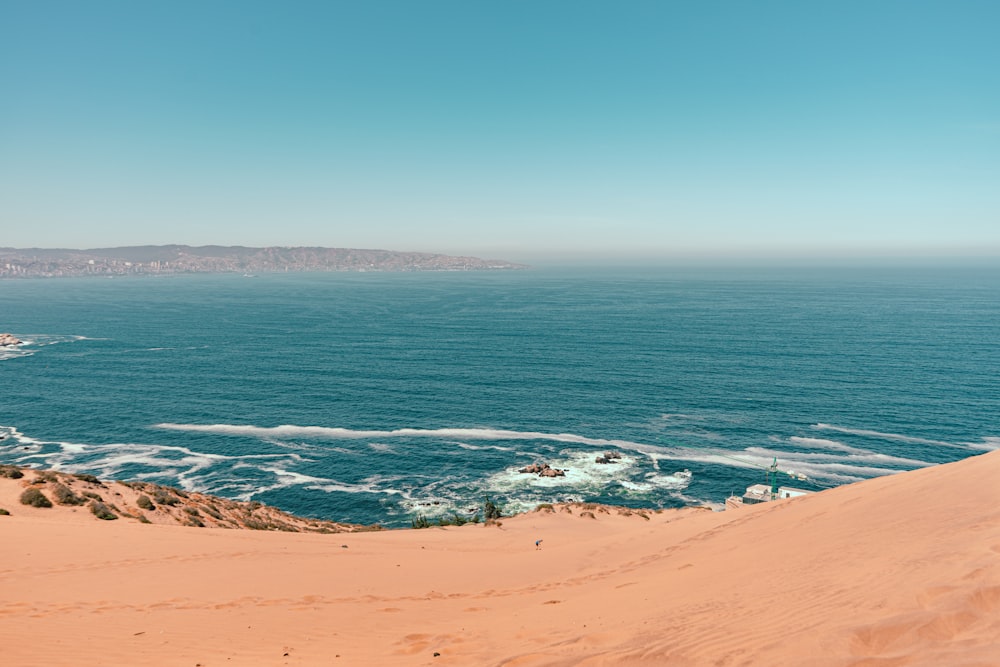 brown sand near body of water during daytime