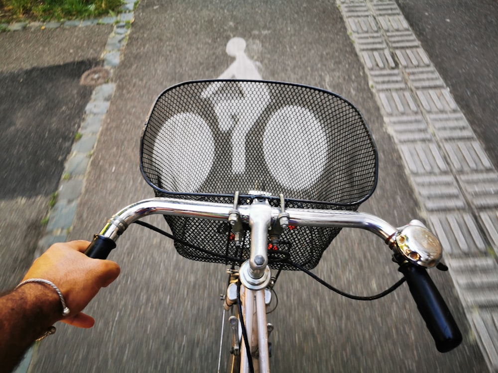 person holding black and silver bicycle handle bar