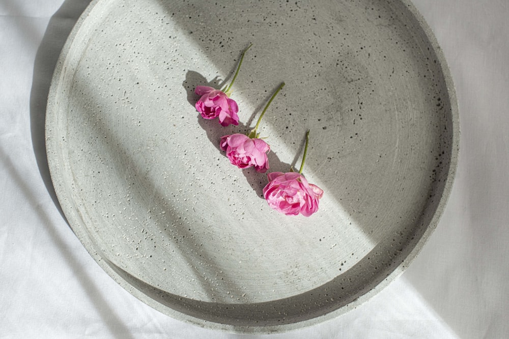 pink flower on gray round plate