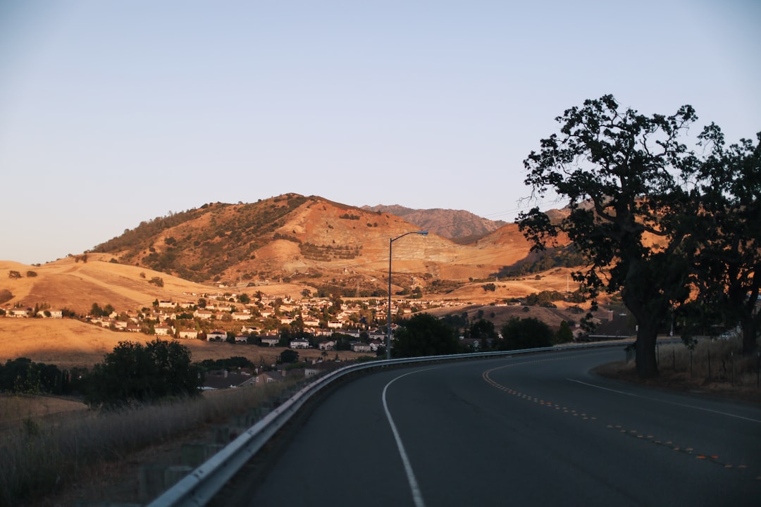 black asphalt road near brown mountains during daytime