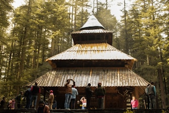 people standing near brown wooden house during daytime