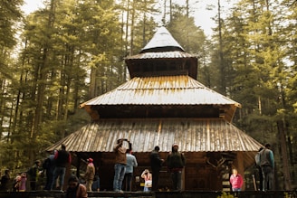 people standing near brown wooden house during daytime