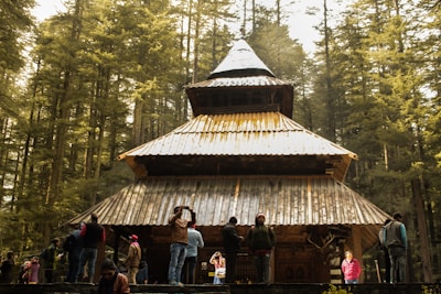 people standing near brown wooden house during daytime