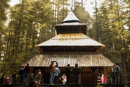 people standing near brown wooden house during daytime