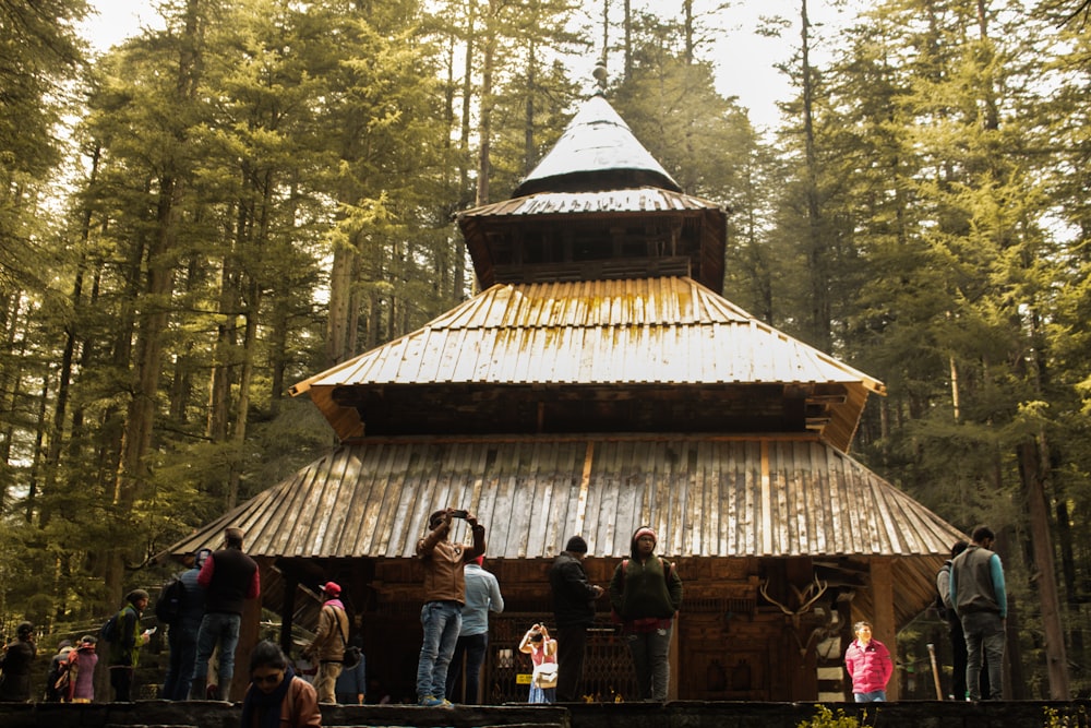 Menschen, die tagsüber in der Nähe von braunem Holzhaus stehen