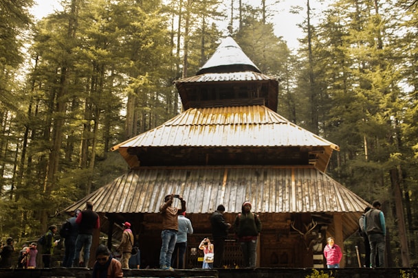 people standing near brown wooden house during daytime