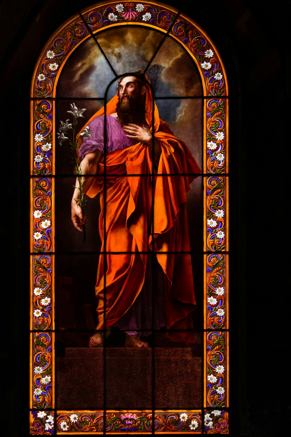 a stained glass window with a painting of jesus